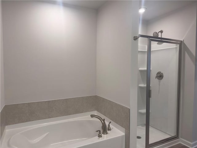 bathroom with a bath and a shower stall