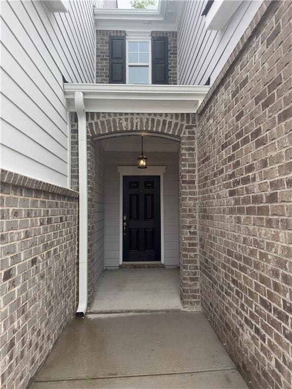 doorway to property with brick siding