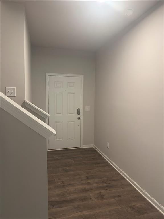 interior space featuring baseboards and dark wood-style floors