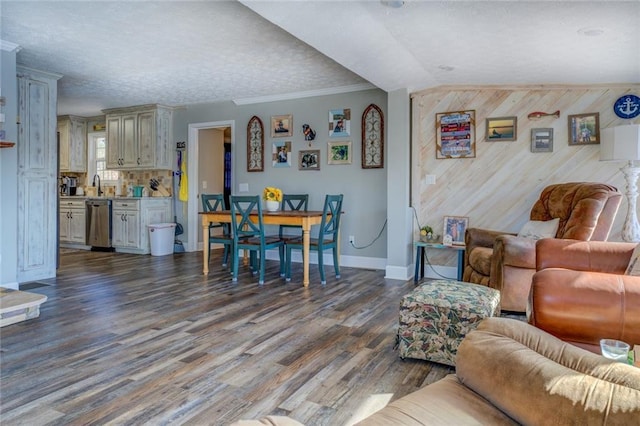 living area featuring ornamental molding, wooden walls, baseboards, and wood finished floors