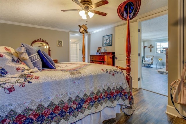 bedroom with a textured ceiling, ornamental molding, and wood finished floors