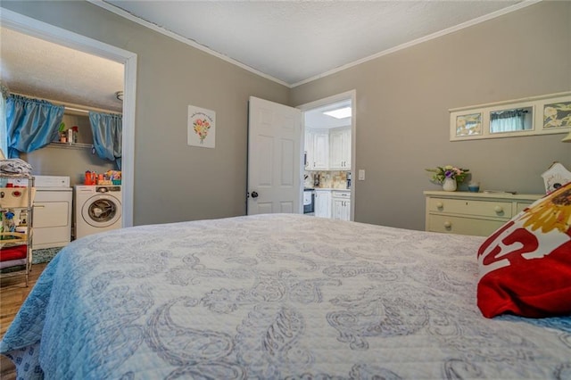 bedroom featuring a closet, crown molding, washer and clothes dryer, and wood finished floors