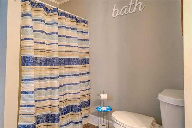 bathroom featuring curtained shower, baseboards, toilet, and wood finished floors