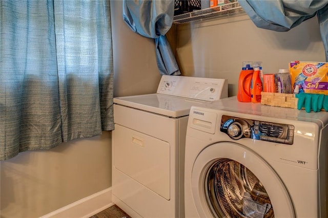 washroom featuring laundry area, washing machine and dryer, and baseboards