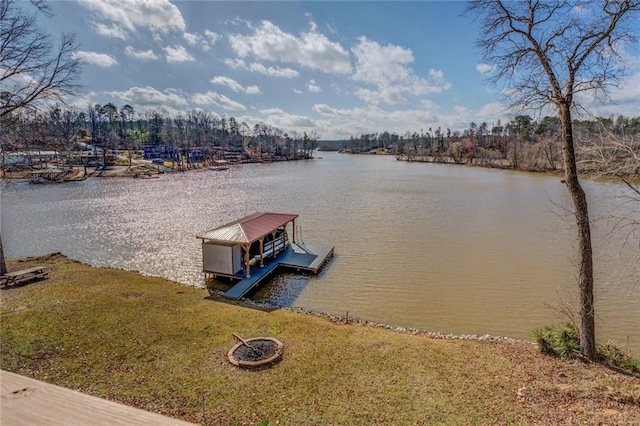 view of dock featuring a fire pit, a yard, and a water view