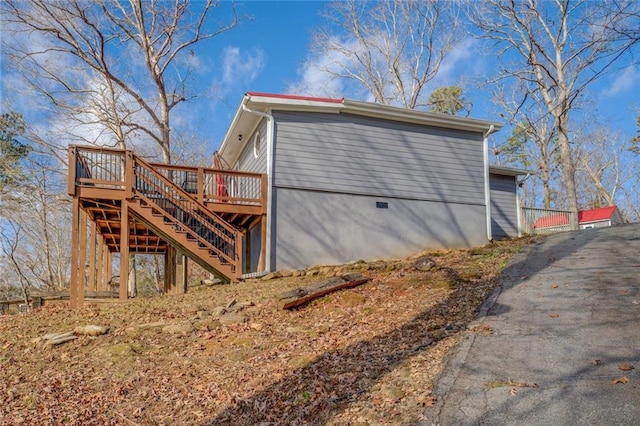 view of side of property featuring stairway and a wooden deck