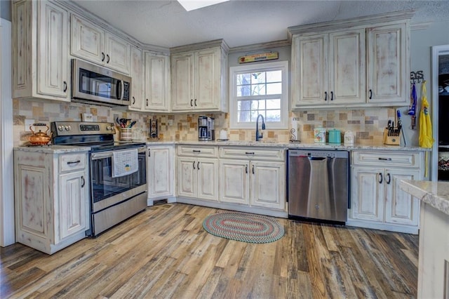 kitchen featuring light wood-style floors, stainless steel appliances, and decorative backsplash