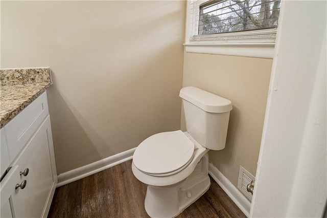 bathroom with hardwood / wood-style flooring, vanity, and toilet