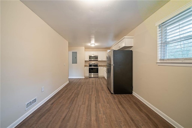 kitchen featuring white cabinetry, stainless steel appliances, dark hardwood / wood-style floors, and electric panel