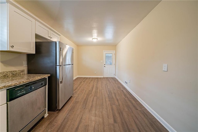 kitchen with white cabinetry, wood-type flooring, stainless steel dishwasher, and light stone counters