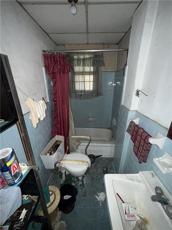 bathroom with shower / bath combination with curtain, toilet, tile patterned flooring, and tile walls