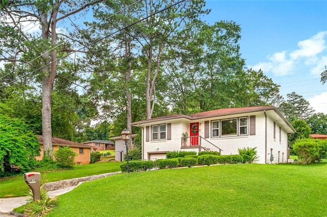 view of front of property featuring an attached garage, brick siding, and a front yard