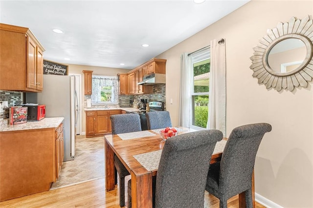 dining area featuring baseboards, light wood-type flooring, and recessed lighting