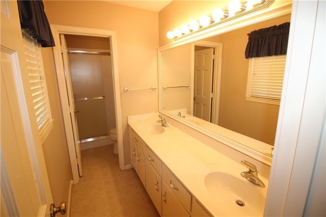 bathroom with a sink, toilet, a shower stall, and tile patterned floors