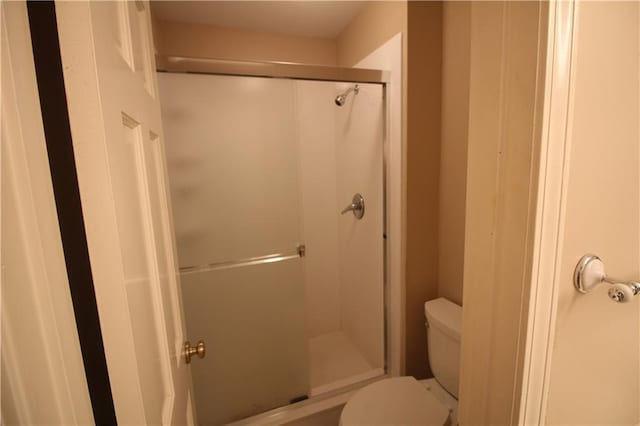 full bath featuring toilet and a shower stall