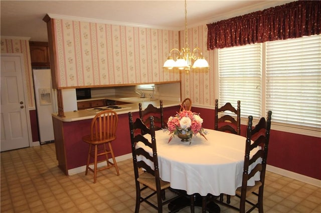 dining space featuring a chandelier, light floors, baseboards, and ornamental molding