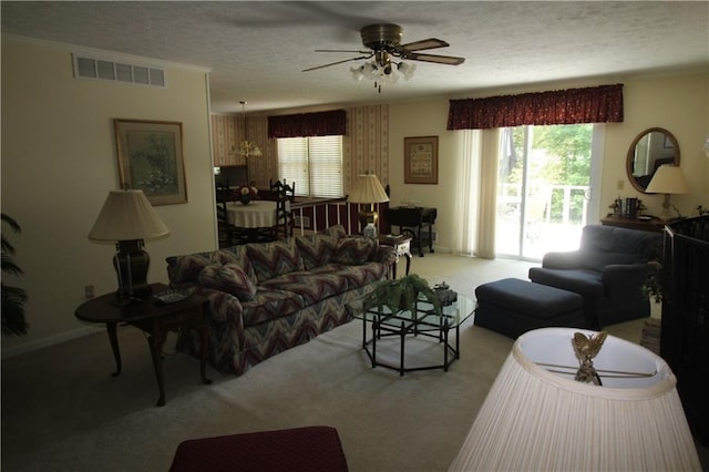 living area with carpet, a textured ceiling, visible vents, and ceiling fan