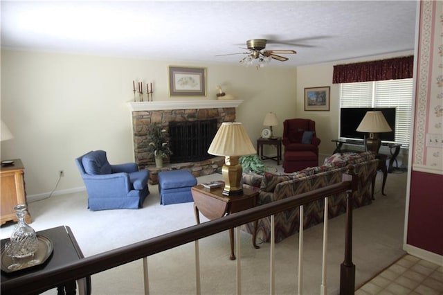 living room featuring baseboards, carpet flooring, a fireplace, and ceiling fan
