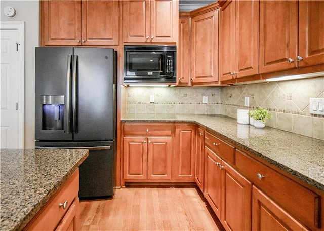 55 Little Barley Ln, Grayson, GA 30017 - kitchen featuring black appliances, light wood-type flooring, light stone countertops, and brown cabinets