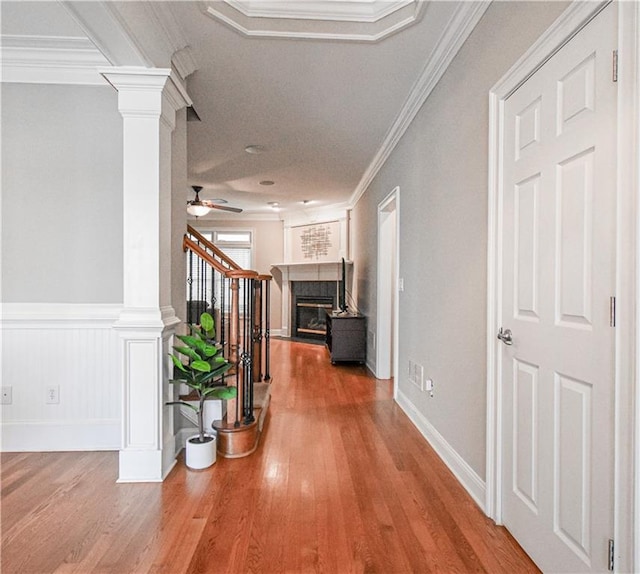55 Little Barley Ln, Grayson, GA 30017 - hallway with decorative columns, wood finished floors, stairs, crown molding, and a wainscoted wall