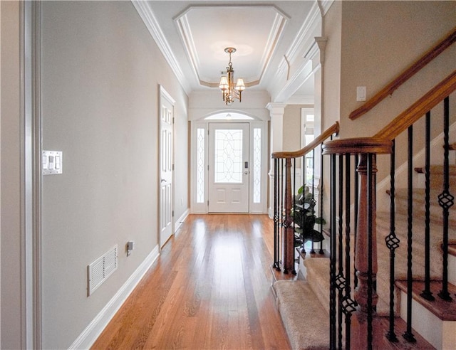 55 Little Barley Ln, Grayson, GA 30017 - entryway featuring wood finished floors, a chandelier, crown molding, a raised ceiling, and baseboards
