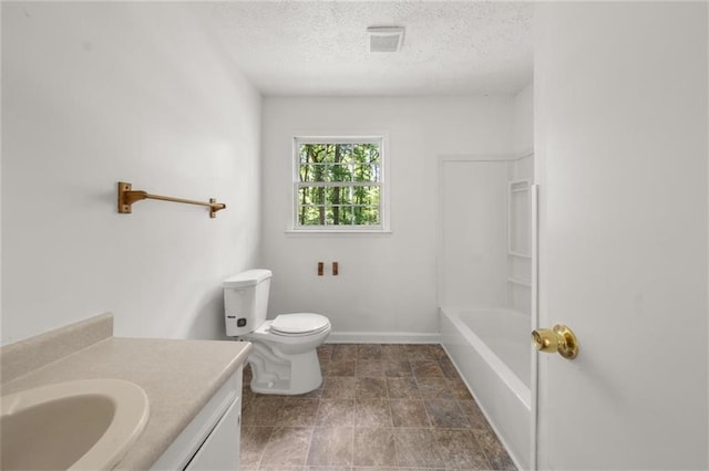 bathroom featuring a textured ceiling, vanity, toilet, and baseboards