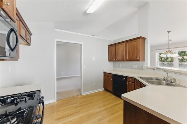 kitchen featuring light wood-style floors, vaulted ceiling, light countertops, black appliances, and a sink