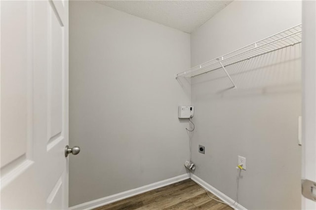 laundry room with laundry area, baseboards, hookup for an electric dryer, and wood finished floors