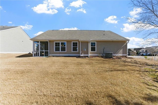 back of property featuring a lawn and a sunroom