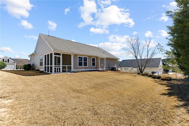 rear view of house with a sunroom and a lawn