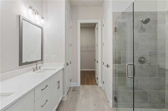 bathroom with an enclosed shower, hardwood / wood-style flooring, and vanity