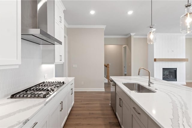 kitchen featuring sink, wall chimney range hood, stainless steel appliances, dark hardwood / wood-style flooring, and light stone countertops