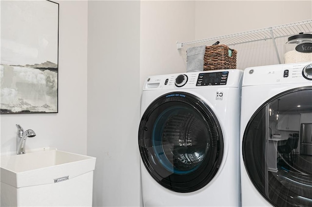 clothes washing area with laundry area, a sink, and independent washer and dryer