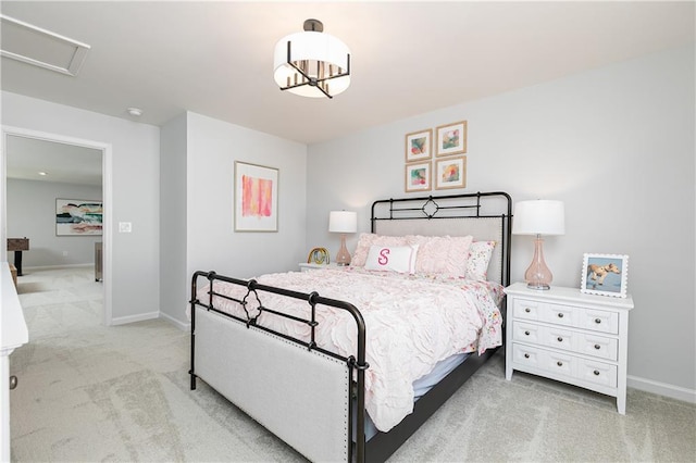 bedroom featuring light carpet, attic access, and baseboards