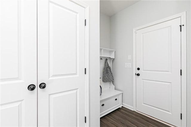 mudroom with dark wood finished floors and baseboards