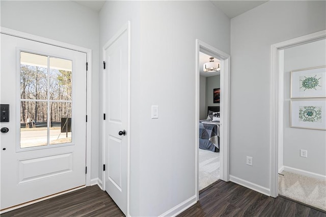 doorway to outside featuring dark wood-type flooring and baseboards