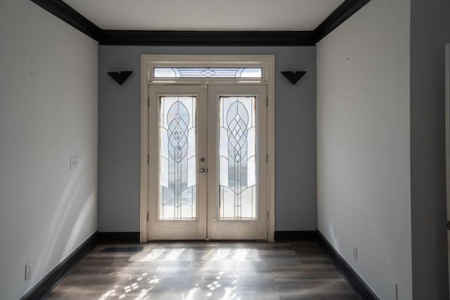 foyer entrance featuring crown molding, wood finished floors, and baseboards