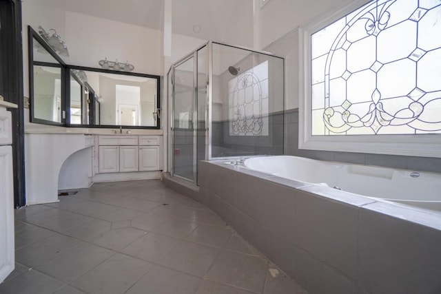 bathroom featuring a bath, tile patterned flooring, a stall shower, and vanity