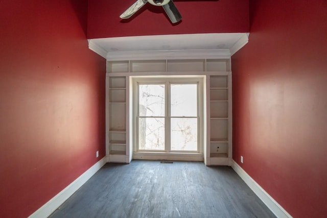 spare room featuring crown molding, wood finished floors, baseboards, and ceiling fan