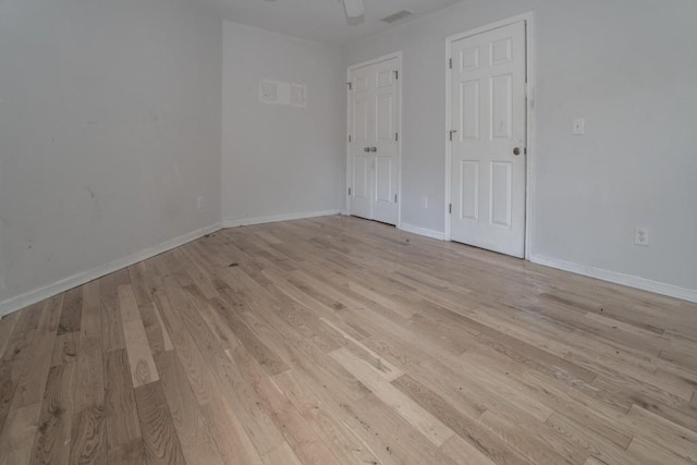 unfurnished bedroom featuring visible vents, light wood-style floors, and baseboards