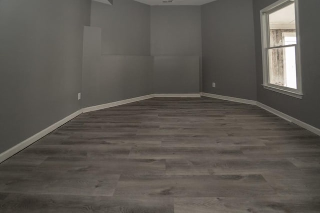 unfurnished room with baseboards and wood finished floors