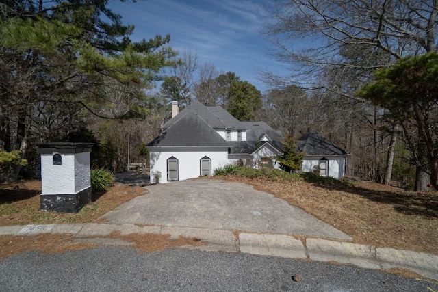 view of front of property featuring driveway and a chimney