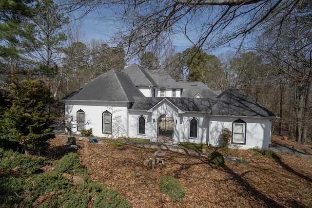 view of front of home with a shingled roof and stucco siding