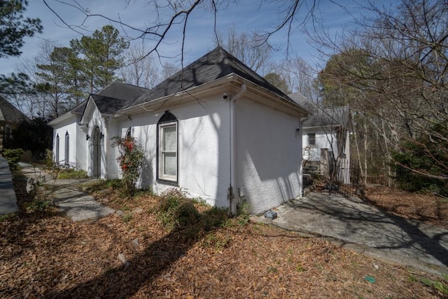 view of property exterior featuring stucco siding and a shingled roof