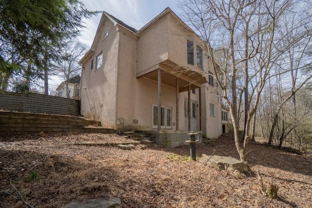 view of property exterior with stucco siding and fence