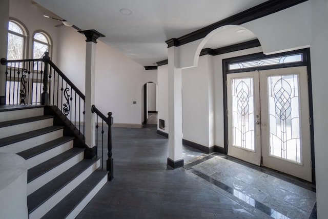 entryway featuring baseboards, french doors, arched walkways, and a healthy amount of sunlight