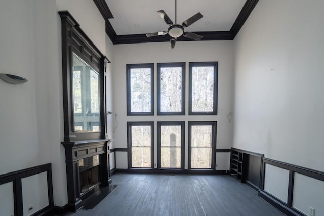 living room with dark wood finished floors, crown molding, a ceiling fan, and a premium fireplace