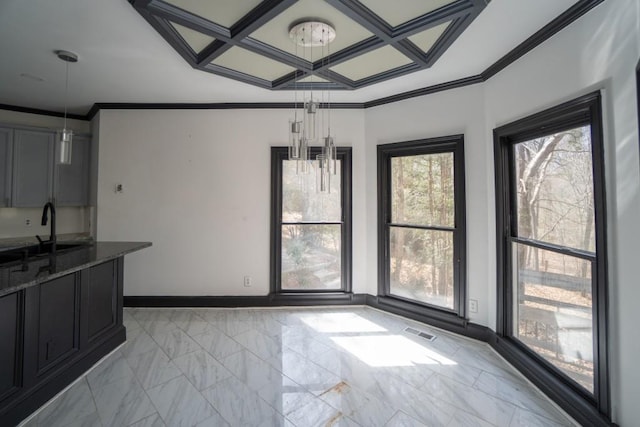 unfurnished dining area featuring marble finish floor, coffered ceiling, crown molding, and a sink