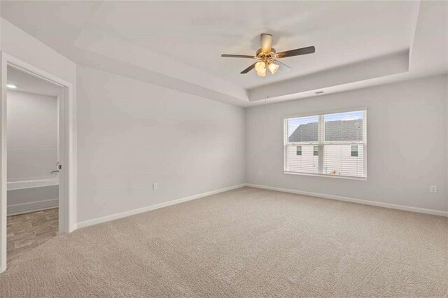 339 Elgin Dr, Lawrenceville, GA 30045 - empty room featuring light carpet, a ceiling fan, a tray ceiling, and baseboards