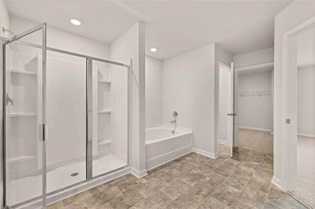 339 Elgin Dr, Lawrenceville, GA 30045 - bathroom with a stall shower, baseboards, recessed lighting, a garden tub, and a walk in closet